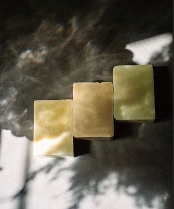 Moody aesthetic photo of three soaps 