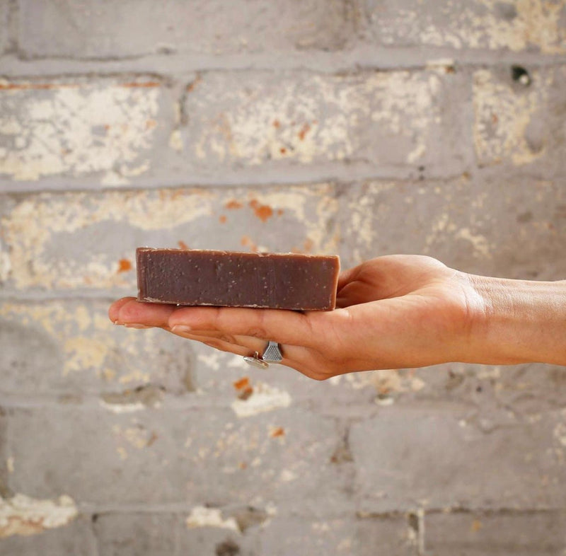 red oak and walnut soap in a woman's hand