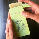yarrow and calendula soap in the packaging with woman's hands